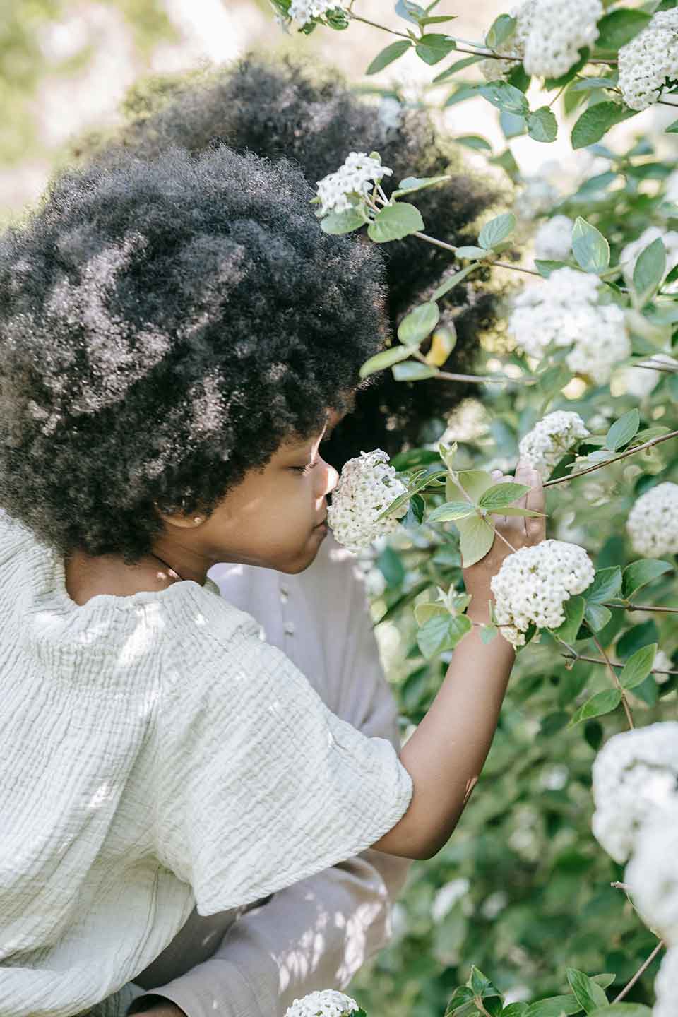 Child smelling flowers with Naeven covered by insurance